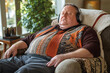 © Centric  - Overweight man is sitting in an armchair wearing headphones and listening to music