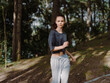 © SHOTPRIME STUDIO - Young athletic woman jogging in a forest, wearing casual sportswear, smiling and enjoying outdoor exercise in the serene nature Fitness and health concept