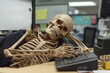 © boyhey - A skeleton is sleeping at a desk in an office cubicle