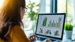 © Johannes - Business asian woman or female worker using a laptop computer to analyse her financial data.business people research or financial strategy in company concept. Laptop white screen mockup.