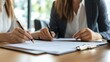 © Johannes - A woman in a business meeting with a client, going over paperwork.