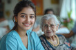 © Suralai - a charming young indian home care lady in light blue uniform giving a glass of water to elderly women