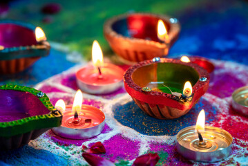 Clay diya lamps lit during diwali celebration. Indian festival Diwali, Diya oil lamps lit on colorful rangoli. Hindu traditional.