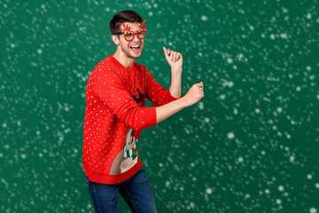 Wall Mural - Portrait of attractive cheerful guy dancing having fun winter festal mood occasion event isolated over green color background