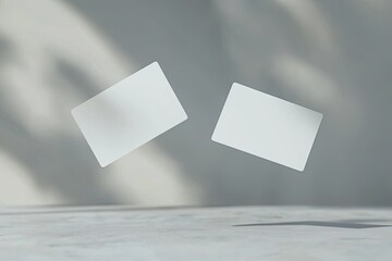 two blank business card mockups floating on a grey background with a soft shadow, two white round-cornered cards flying in the air for design presentation and branding mock-up template