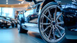 © Anoo - Close-up view of shiny black luxury car wheels in an upscale showroom showcasing modern automobiles for discerning customers