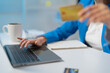 © Tj - Businesswoman shops online with laptop and credit card, surrounded by office items. She browses products, takes advantage of discounts, and manages finances from her desk