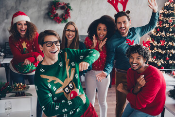 Photo of six overjoyed corporate workers dancing celebrate xmas atmosphere office party indoors