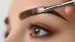 © anonymous - A close-up of an eye and eyebrow being groomed with a brush.