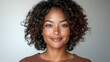 © tuiphotoengineer - Smiling and Confident African American Gen Z Woman With Curly Hair Framing Her Face Standing in a T Shirt Against a Clean White Background  Portrait of a Stylish