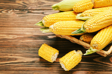 Wall Mural - Ripe corn in basket on brown wooden table