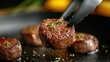 © familymedia - Close-up of a succulent steak medallion gripped by steel tongs, highlighted with rosemary sprig, emphasizing its juicy tenderness and savory appeal.
