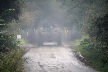 commander and gunner directing a british army challenger 2 ii fv4034 main battle tank along a small 