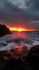 Poster - Dramatic sunset over the ocean with crashing waves and rocky shoreline.