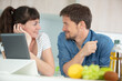 © auremar - couple in home kitchen using electronic tablet