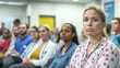 © alisluch - A concerned group of people attentively listening during a serious meeting or seminar, with a woman in the foreground looking focused. Copy space