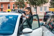 © Srdjan - Young business woman having issue and hard time to enter the car on drivers door because of tight parking lot space and space between the cars. Bad driver parking concept