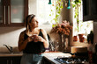 © Malambo/peopleimages.com - Home, kitchen and woman with coffee for thinking, remember and nostalgic memory with smile by window. House, female person and reflection with tea cup for drinking, ideas and inspiration in morning