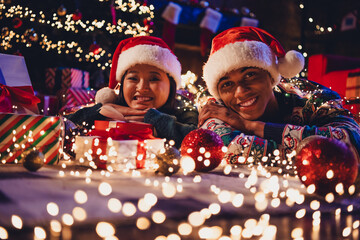 Portrait of two young people couple presents enjoyment celebrate x-mas new year garland lights flat indoors