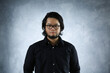 © Harris Kharisma - portrait of an Asian man in black shirt wearing eye glasses on abstract background
