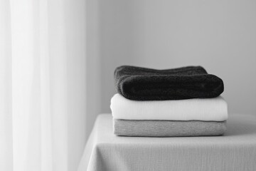 Aufkleber - Soft, minimal sportswear is arranged in neat folds on a smooth table, emphasizing a calm and organized aesthetic in a well-lit room. Generative AI