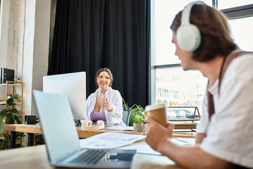 A cheerful young plus size woman shares a delightful moment with her male companion at work.