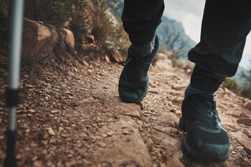 Hiking, closeup and walking pole with shoes in nature for relax, health and adventure. Challenge, wellness and holiday with person and trekking stick for mountain path, fitness and camping vacation