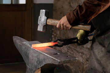 Craftsman - blacksmith manually forging the molten metal with a hammer