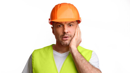 Poster - Shocked Builder Man Touching Face In Shock Having Problems At Construction Building Looking At Camera Posing Over White Studio Background. Build Service Issues. Panorama