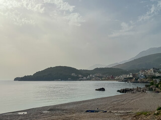 Panoramic view of the picturesque coastline of coastal tourist town Himare, Vlore, Albania. Idyllic sand beach Potami with scenic vistas of majestic Ceraunian mountains. Summer vacation concept