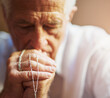 © peopleimages.com - Clinging on to his belief. Cropped shot of a senior man holding a rosary while praying for a miracle.