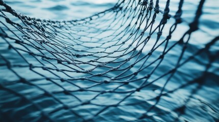 Close-up of a fishing net with a blue water background.
