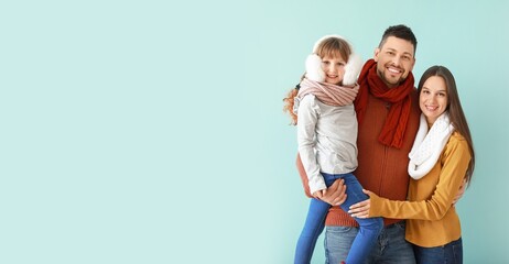 Poster - Happy family in winter clothes on light blue background with space for text