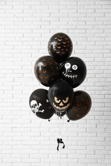 Poster - Different black Halloween balloons near light brick wall in room