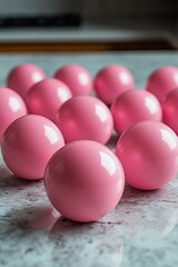 Wall Mural - A collection of shiny pink balls arranged on a marble surface in a bright indoor setting