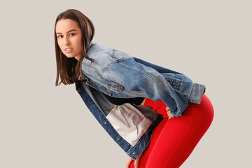 Poster - Stylish young woman in denim jacket on light background