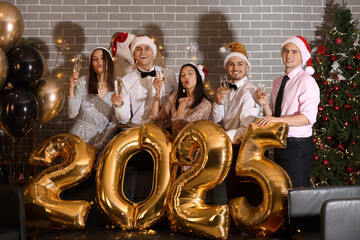 Wall Mural - Group of friends with champagne and figure 2024 celebrating New Year at party