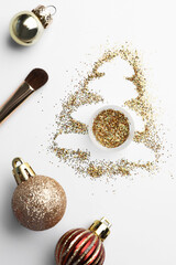 Poster - Christmas tree made of glitter, balls and makeup brush on white background, flat lay