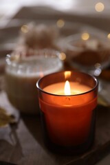 Wall Mural - Tray with burning candle on blurred background. Autumn atmosphere