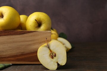 Wall Mural - Ripe yellow apples in crate on wooden table, closeup. Space for text