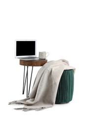 Wall Mural - Laptop, cup of coffee on stand and pouf with plaid on white background