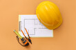 © Pixel-Shot - Architect's supplies with hardhat and house plan on orange background