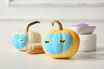 Wall Mural - Pumpkins with clay masks and bath supplies on white grunge table against wooden background