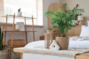 Canvas Print - Comfortable bed and bench with houseplant, vase and lantern in bedroom. Closeup