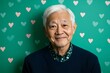 © Maelgoa - A proud Asian grandfather with white hair and black eyes on Grandfather's Day against a solid green background with heart patterns 3