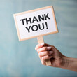 © Aurora - a woman hand holding a sign saying thank you, thank you message