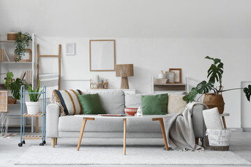 Wall Mural - Cozy sofa, coffee table and houseplants in interior of living room