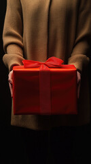 Wall Mural - Woman holding red gift box, smiling joyfully.