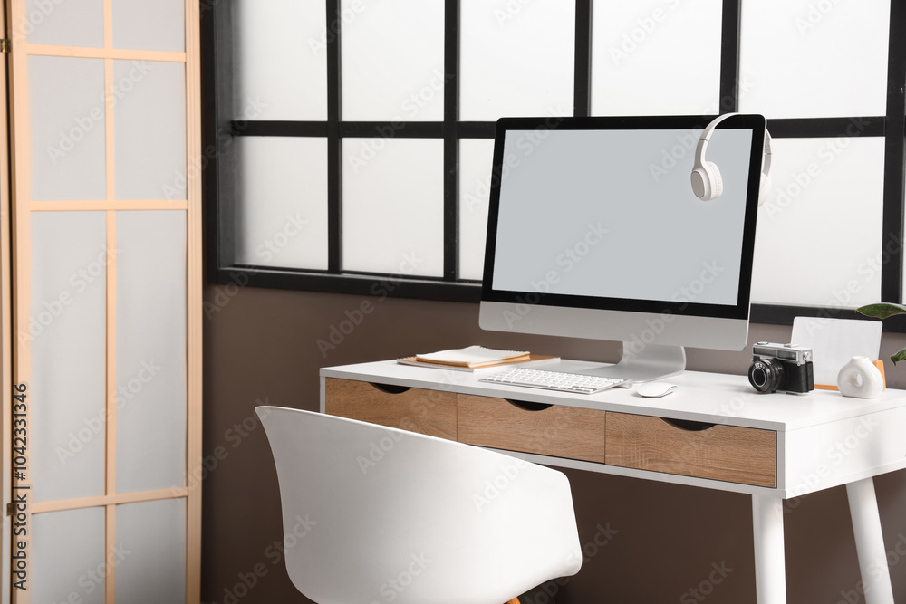 Programmer's workplace with headphones in interior of living room