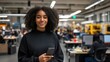 © Krystian - Young Businesswoman Smiling Holding Phone In Bright Open Modern Office Setting